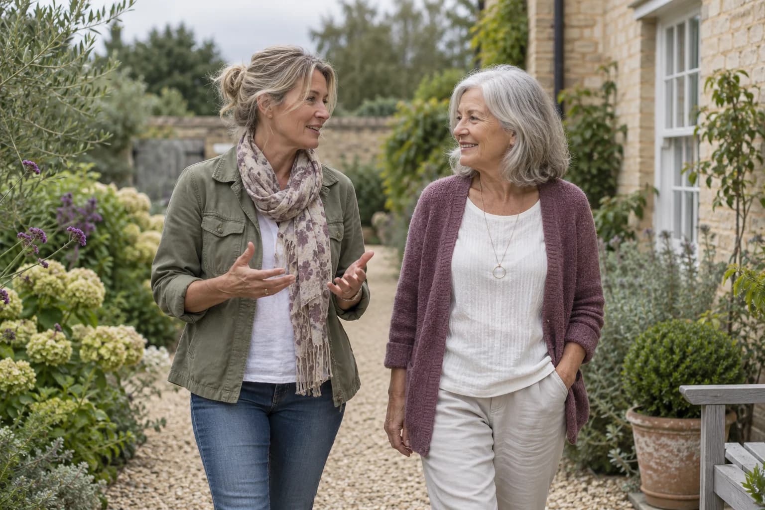 Two mature women turning towards each other during a conversation on a garden path