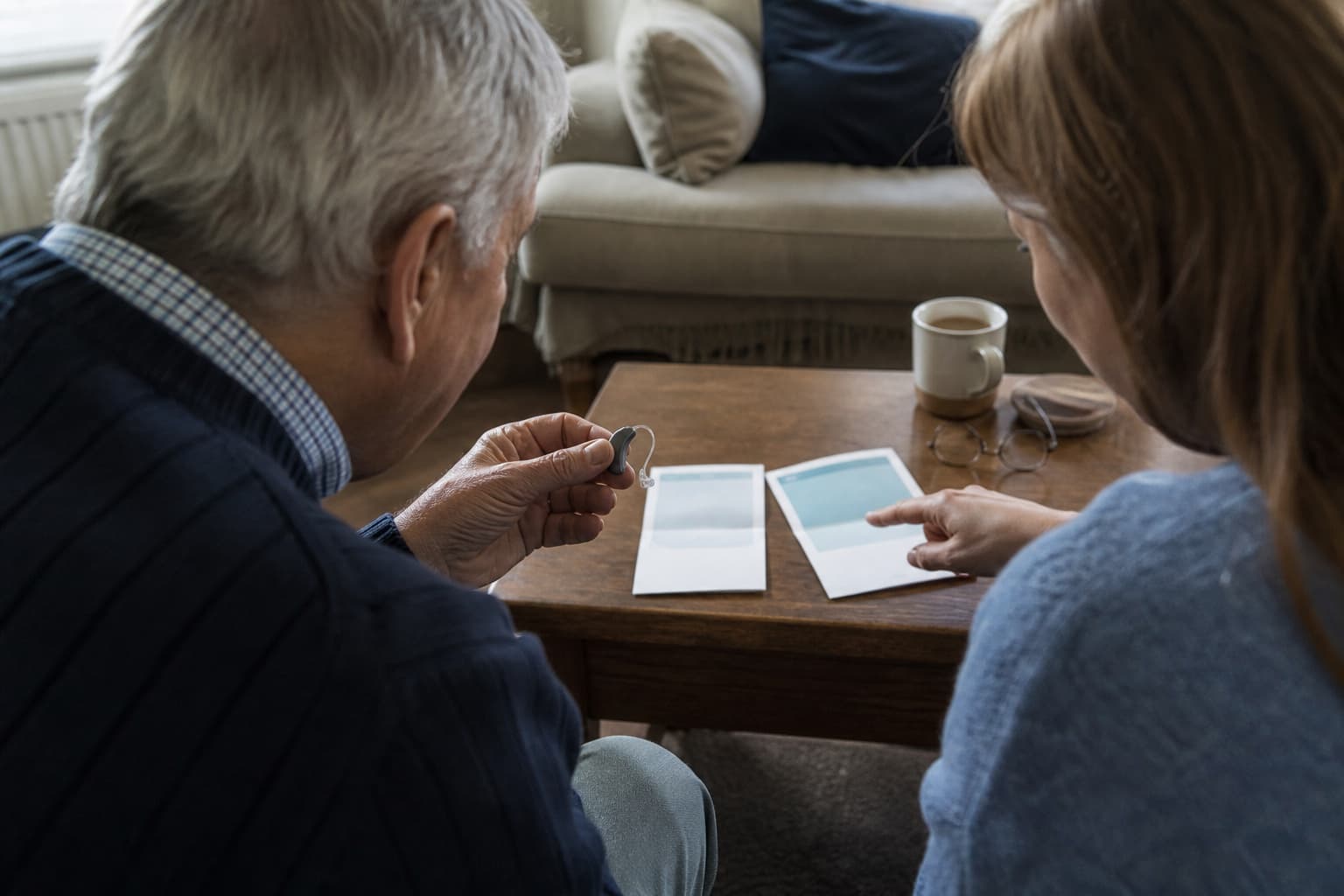 Older adult comparing hearing-aid care options with support from a family member at home