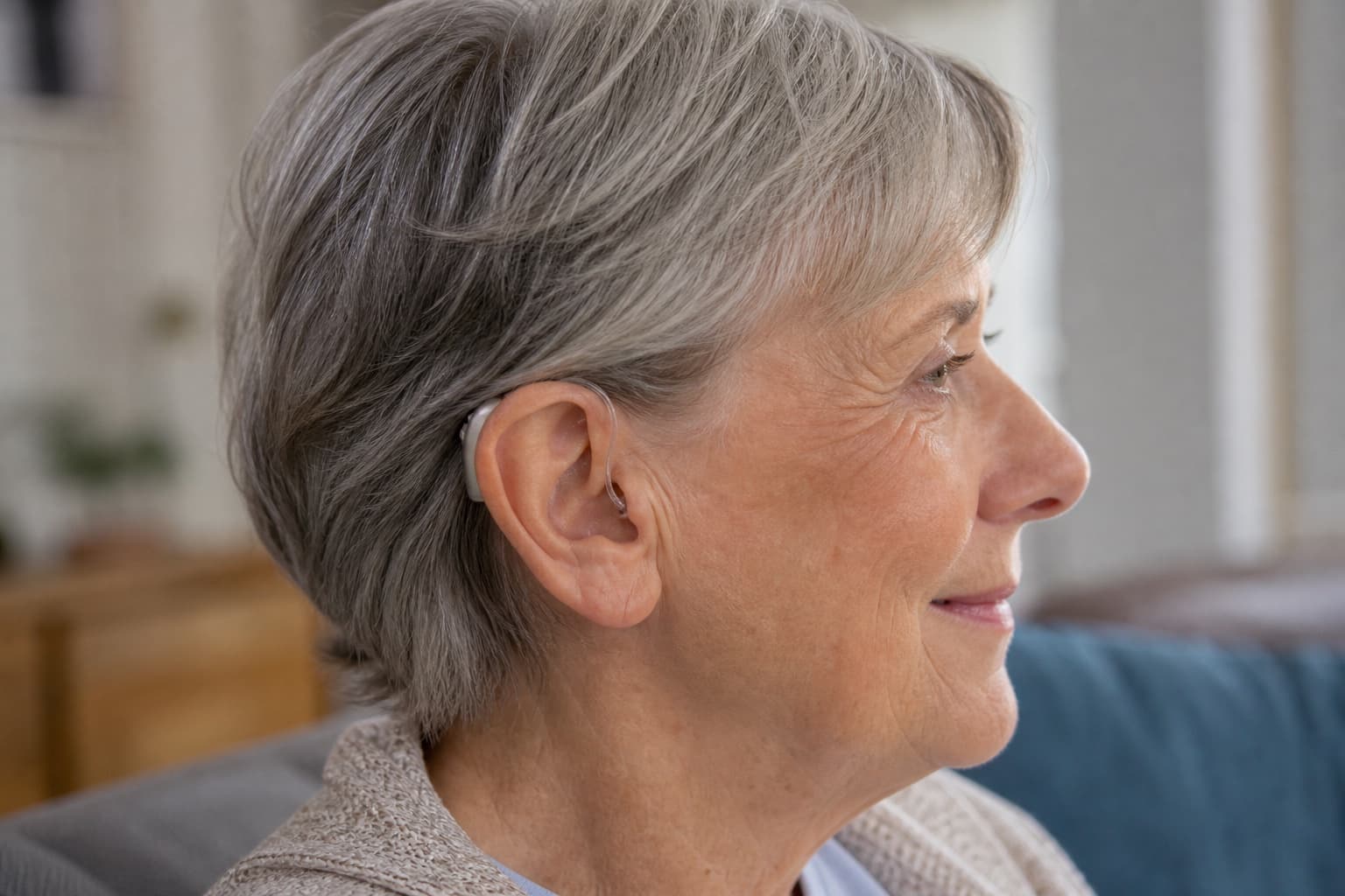 Older woman wearing a discreet receiver-in-canal hearing aid with a thin wire entering the ear canal