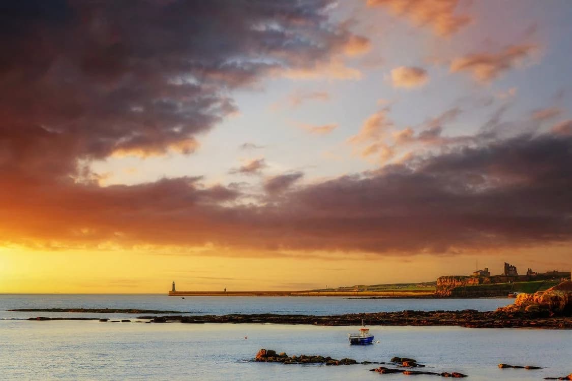 Evening sunlight over Tynemouth Priory, the pier and the North East coastline