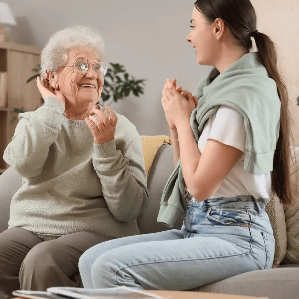An older adult discussing hearing concerns with a family member at home in Gateshead